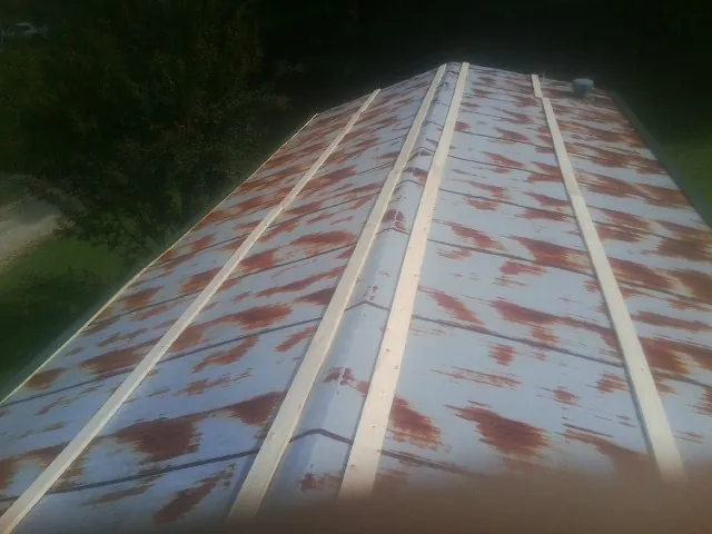 Rusted metal roof panels with new wood purlins before replacement — Storm Damage Roof Repair in Williamson by Roofing Brothers